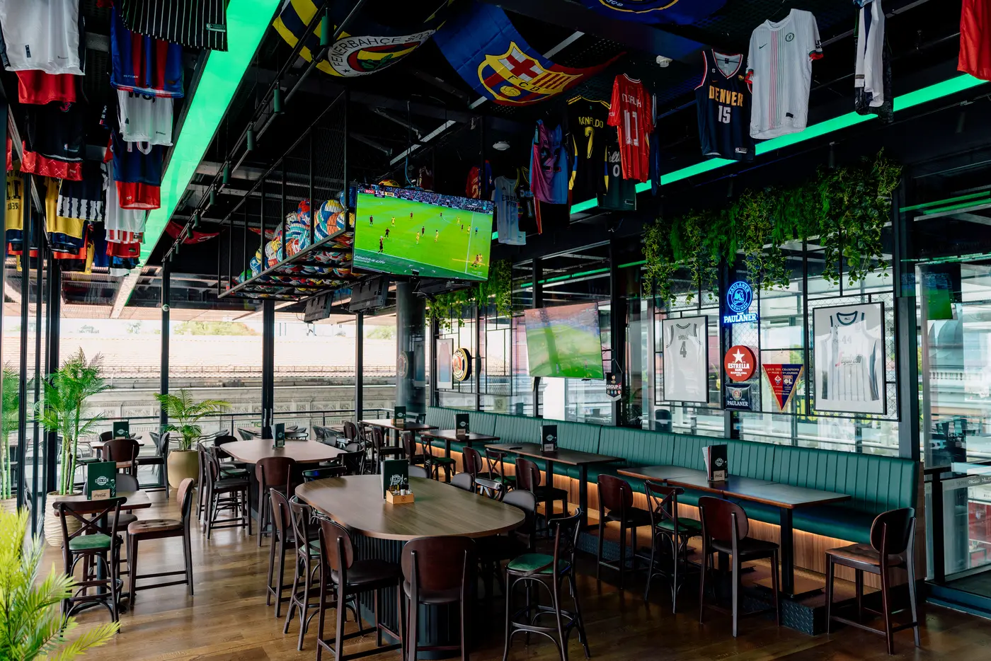 Liga Pub in Rajićeva shopping centre — high oval table, bar stools and green upholstered banquettes