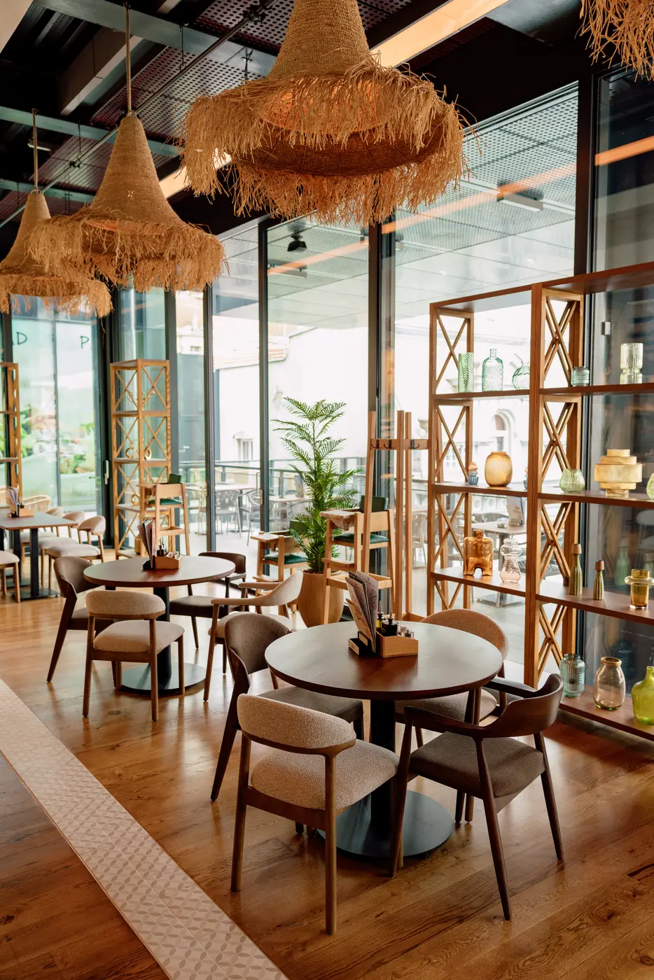 Monument Rajićeva restaurant — dining room along the glass façade with round tables and chairs